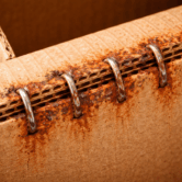 Corrosion of stitching wire in corrugated boxes showing rusted staples caused by moisture and paper chemistry