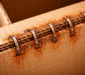 Corrosion of stitching wire in corrugated boxes showing rusted staples caused by moisture and paper chemistry